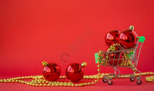 星期五在微型手推车中赠送圣诞球和红色背景上的装饰品绿色结尾图片