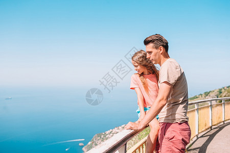 人们白种意大利的暑假阿马尔菲海岸背景下的年轻人和小女儿意大利阿马尔菲海岸背景下的父亲和孩子暑假家庭美丽图片