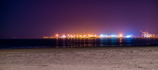 夜晚旅行热的Blankenberge海滩岸的线夜间照亮远处工业地形有彩色灯光图片