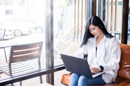 人们亚洲女企业家正在使用笔记本电脑并穿戴耳机参加在线会议和家工作亚洲女商人正在使用笔记本电脑和耳机沟通视频图片
