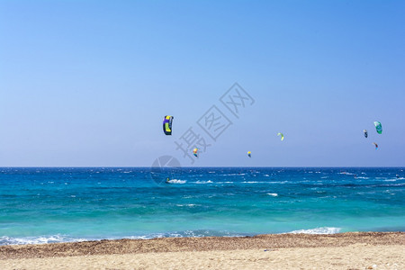 假期木板运动的希腊莱夫卡斯岛的AgiosIoannis海滩希腊莱夫卡斯岛的风筝冲浪者海滩的彩色电力风筝横跨天空图片
