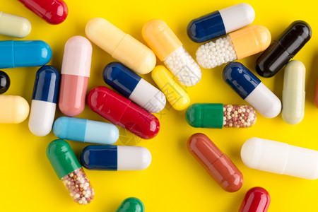 玻璃不同颜色背景的药丸和不同颜色背景的胶囊有不同药丸店瓶子图片