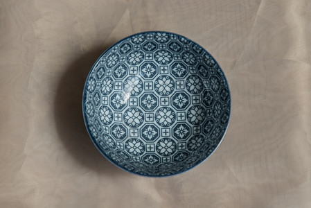 圆形的釉面粉色桌布上的蓝瓷碗陶餐具美丽安排顶视图选择焦点经典的图片