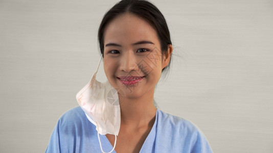 消除接种疫苗离开年轻亚洲妇女摘下面罩从脸上抹去隔离结束的概念并赢得COVID19名年轻亚洲妇女脱下面罩从脸部除去图片