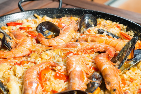蓝色的盘子巴伦西亚帕耶拉美味的海产食品大米和虾香料图片
