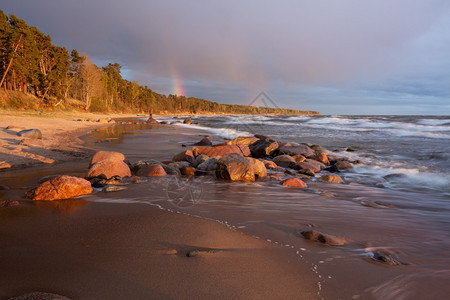 城市海浪太阳拉脱维亚波罗的海图贾市哈带有岩石和沙子图片