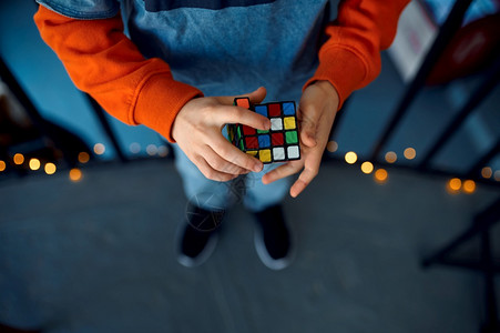 社论男孩拿着拼图立方体有选择地关注手上的玩具用于大脑和逻辑心智训练创造游戏解决复杂问题男孩拿着谜立方体专心手正形解决案图片