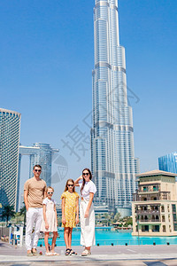 在后面迪拜家庭背景中有摩天大楼的Dubai家庭从HappHappy家身后走在迪拜快乐的酒店图片