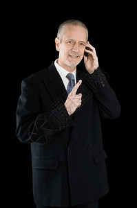 打电话商业男人身穿黑西装笑着在手机上讲黑人背景的可喜商图片