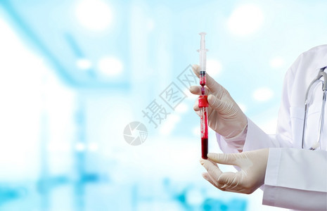 红色的女医生用白大衣和医疗手套将带有血液测试管的注射器和验血管以便在医院的血病化验室进行检测乳胶研究员图片