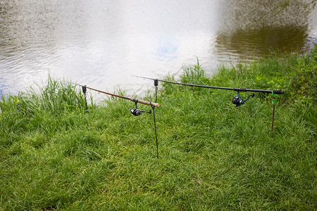 自然钓鱼竿放在池塘岸边的架子上户外休闲夏天假期休息日钓鱼弯曲天空图片