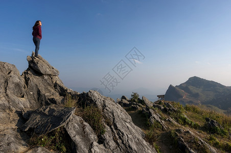 攀登土井户外站在岩石顶端的女游客DoiPhaTang旅游点Sunset景点美丽清Rairsqopos隐藏天堂泰国DoiTang日图片
