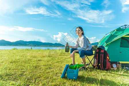 露营时喝酒饮在草地上露营的女人图片