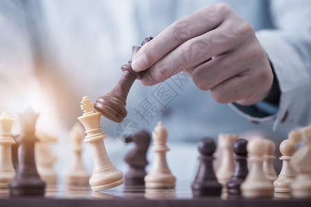 将死商人在竞争成功游戏概念战略和成功管理或领导方面玩象棋游戏并成功管理或领导才能改进行政人员图片