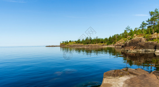 户外黄色的欧洲湖边美丽石头海岸风景环绕着山上湖泊和小溪的岛屿图片