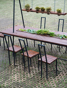 家具季节外部现代木制桌椅和子由植物园砖地板上的植物装饰在园中图片