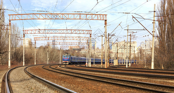 汽车作品城市景观背下蓝色移动铁路旅客列车的景观旅客在城市景观背下的铁轨上行驶老图片