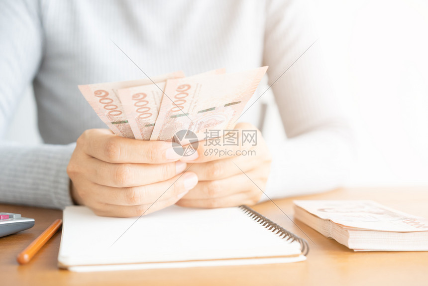 现金预算贷款亚洲女人用计算器数钱的特写女人计算家里的支出图片
