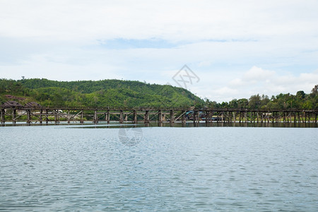 木头建造横跨河流的木环桥背面和河两边的山峰流动图片