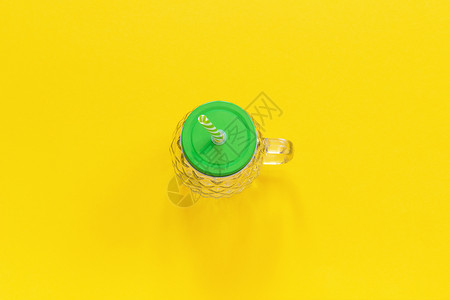 果汁菠萝形式的空玻璃罐带绿色盖子和稻草用于黄色背景的水果或蔬菜冰沙鸡尾酒和其他饮料黄色背景上的其他饮料顶视图复制空间模板厨具布局图片