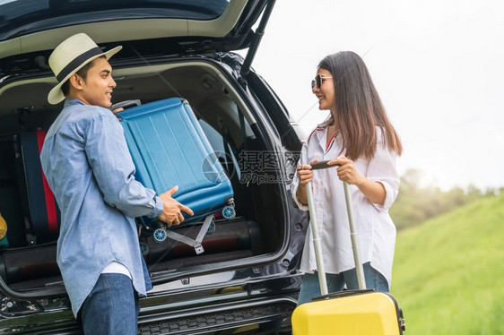 好的家庭约会亚裔男子帮助女在长周末旅行期间将李箱从汽车上搬走夫妇有与黄行李度假的公路旅行人们的生活方式和交通概念尼斯男人主题图片