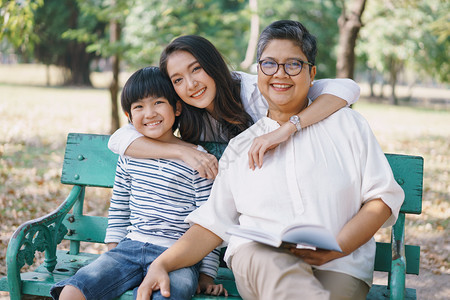 奶坐着幸福的亚洲家庭母亲祖和儿子坐在长椅上母亲公园拥抱他们俩家庭节日生活方式的概念在家庭节日中的生活方式概念自然图片