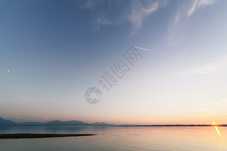 在巴伐利亚湖中日落与月和太阳同时交汇的天文结合湖边和平蓝色的图片