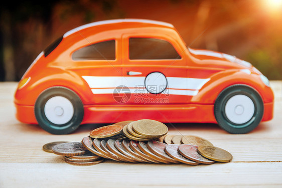 用泰铢硬币储蓄钱财或保险概念的木桌板汽车模型蓝色的金融成功图片
