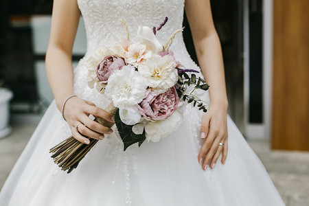 穿着婚纱的新娘手里拿着一束鲜花图片