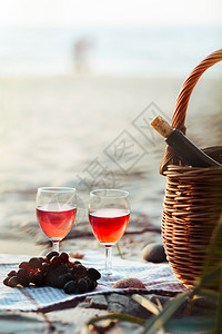 篮子旁边有葡萄和铁篮酒瓶在海边图片