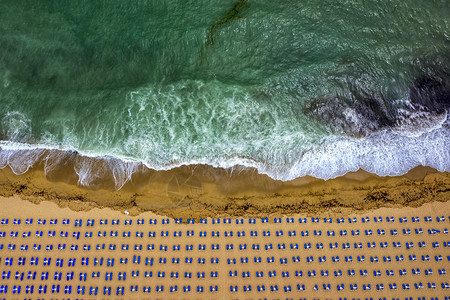 美丽松弛以白色雨伞休息椅和松绿海热带滨岸线暑假的空中景象令人惊叹的海滩场景图片