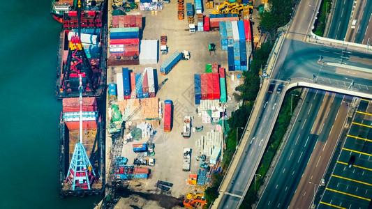卡车运输在香港繁忙的口终点站观视用起重机载运货物集装箱的轮交通车辆图片