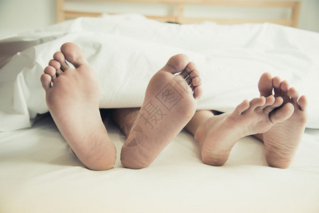 治疗在卧室的毯子下赤脚恋人享受和幸福情人节日活动主题假日早晨床单身体图片