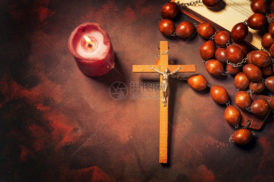 天主教红色的与蜡烛和圣经书精神氛围宗教概念交叉的大木罗萨里珠子和方济各会图片