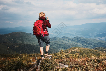 渡过与自然相近的暑假在山顶欣喜地风景全的树桩上站立着女人的后视线在大自然附近度过暑假运动开支远足图片