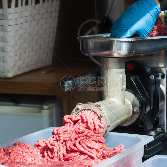 器具过程将肉重新放入机器的手研磨和床它能把肉放回机器里品尝图片