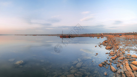 矿物水夏季日落时湖和旧船的全景日落时盐湖的全景日落时自然图片