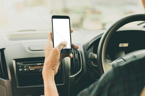 技术卫星保持驾驶汽车时手智能机空白屏幕的人图片