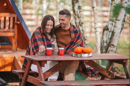 家庭年轻的毯子秋天家里有咖啡因的年轻夫妇秋天在他们家院子里图片