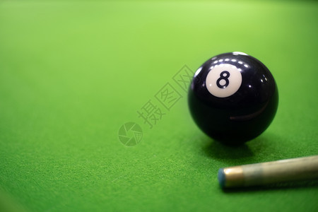 享受桌面上Snooker或台球牌游戏的近端团体瞄准图片