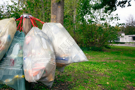 塑料垃圾袋挂在街上捡垃圾等待破坏回收和环境概念社区塑料垃圾袋挂在街上捡垃圾等待破坏回收和环境概念为了工作肮脏的图片