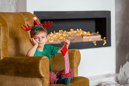圣诞装扮的小男孩等礼物图片