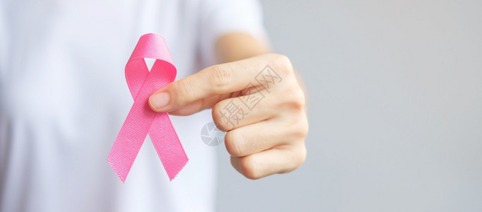 手握粉色丝带预防乳腺癌概念图片