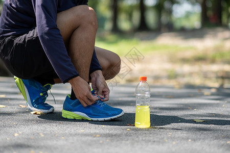 青年运动员男子在公园户外绑鞋男跑者准备在外面的路上慢跑AsianFitness在早晨健康与体育概念中步行和徒锻炼人道肥胖喝图片