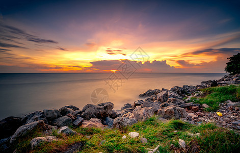 海洋阳光日落时在石滩上的岩美丽海边夕阳天紫光海与空黄昏时的热带海风云平静和放松生命自然景观清奎尔和平的概念夏天图片