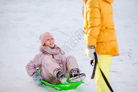 喜悦享受可爱的小女孩在雪中滑和户外玩地游在圣诞节前夕家庭度假在寒冬雪日可喜的快乐小女孩滑雪天图片