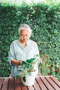 家庭活动一位快乐和微笑的亚洲老年妇女在退休后家里安放业余爱好为老年人创造幸福生活方式和良好健康的概念对年长者来说高级的图片