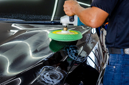 将要清洁器从事打磨涂层汽车的工人对进行涂漆有助于消除汽车表面的污染物a工作人员刮图片