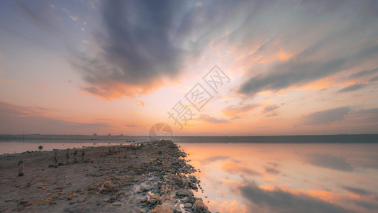 日落的云层反射在温暖的夏夜寒暑水面上日落时盐湖全景乌克兰颜色沙漠图片