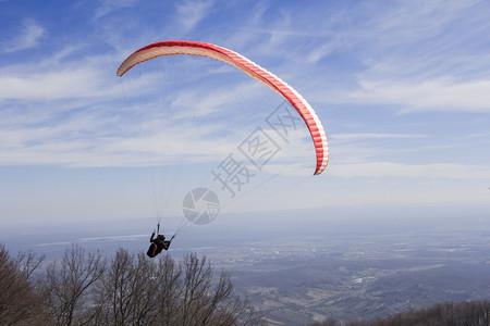 村庄滑翔伞从山上飞到谷传单夏天图片